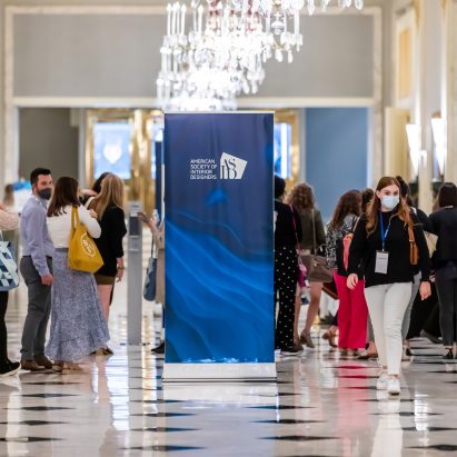 A photograph of people walking through a conference hall