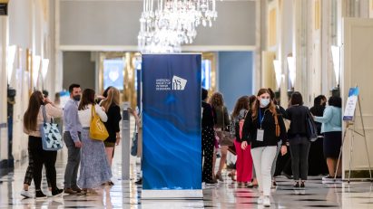 A photograph of people walking through a conference hall