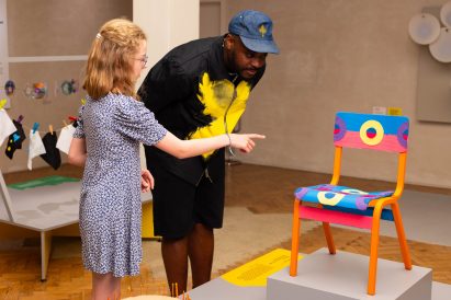 A student looking at her colourful upcycled chair design