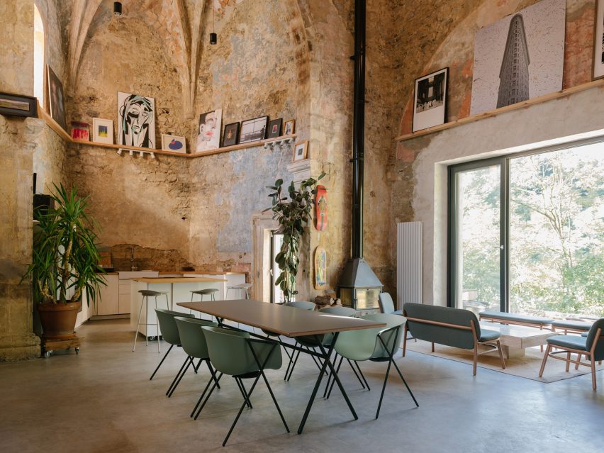 Chairs, table and frames in stone-walled room