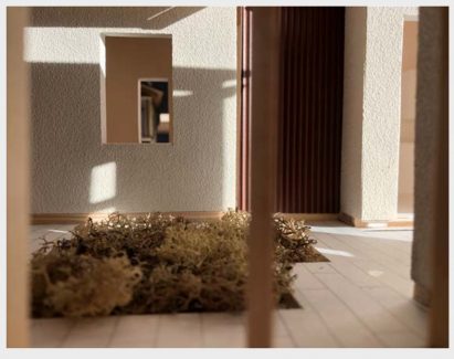 A wall with a window and foliage outside