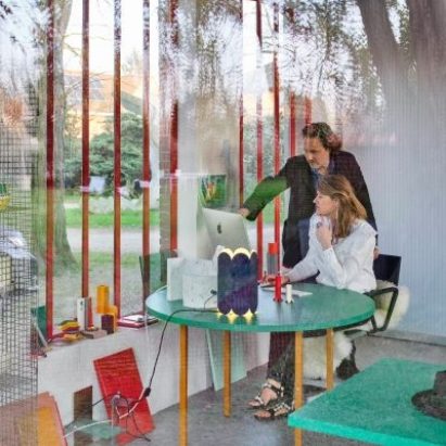 Photograph showing two people working in a glazed officee