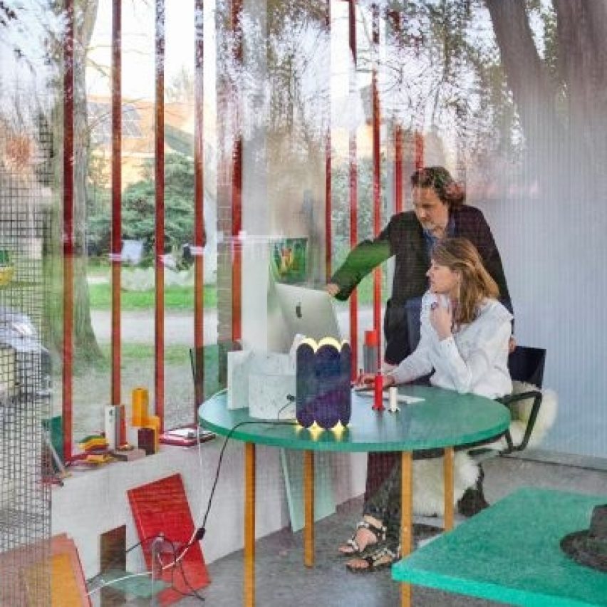 Photograph showing two people working in a glazed officee