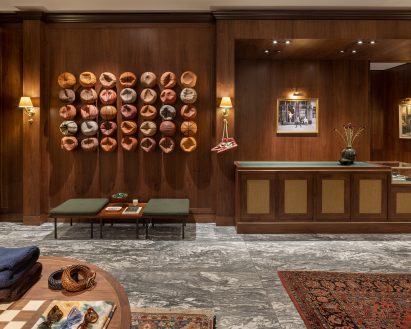 Walnut wall panelling with basketball artwork in London retail space designed by Sarita Posada