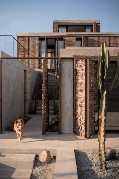 Rammed earth home with wood folding doors by Alfredo Navarro Tiznado