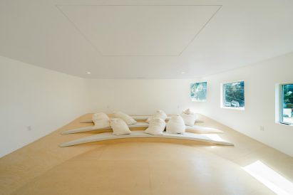 Bright home theatre space with cushioned tiered seating and wooden floor