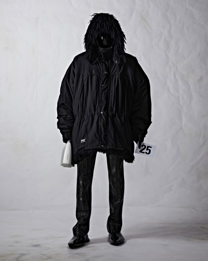 A model wearing black clothes and holding a bag
