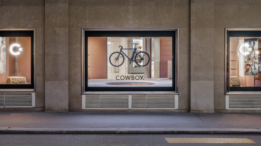 Exterior shop of bike hanging in window of Cowboy e-bike shop in Paris by Ciguë