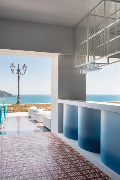 Oceanside cocktail bar by Gae Avitabile leading to exterior seating area on terrace