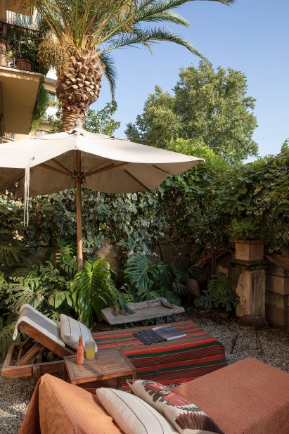 Garden area outside Rome apartment with trees and lounge area