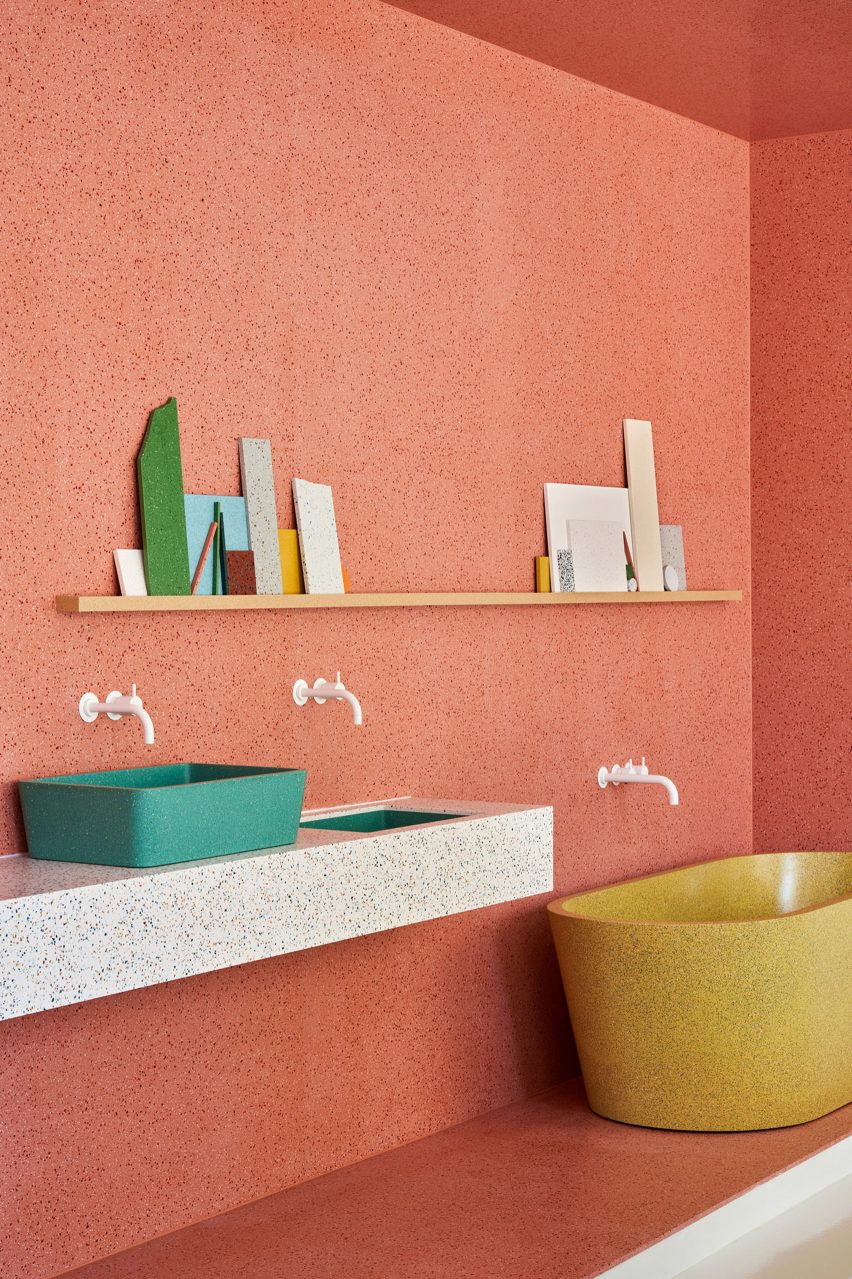Salmon-pink display area in Durat showroom showing different sink styles and a freestanding bathtub
