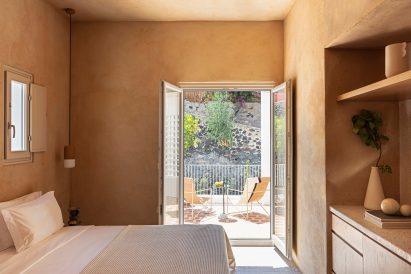 A room inside the hotel, with a bed and glass doors that open on to a terrace