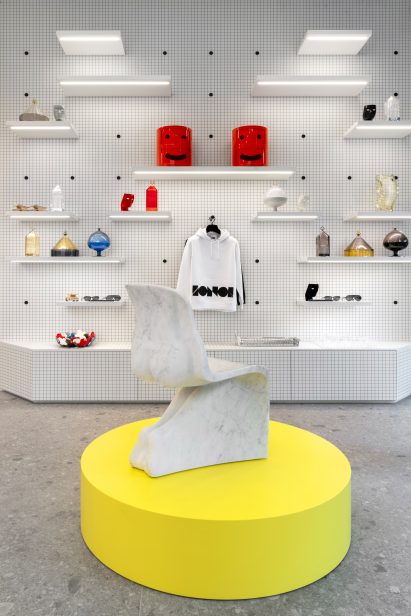 Grid-patterned wall and yellow display units in Milan gallery by Fabio Novembre