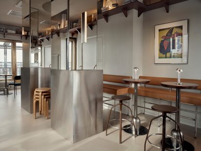 Seating area of bar in Hotel Torni with reflective steel surfaces and lights