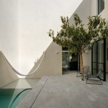Light courtyard with a white hammock and large tree