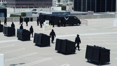 Image of a carpark filled with Yeezy Gap engineered by Balenciaga black waste bins