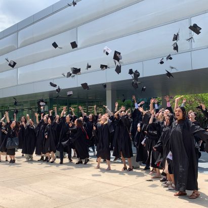 Students in graduation gowns throwing their caps in the air