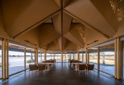 Tables in China restaurant under tree-shaped canopy surrounded by glass walls