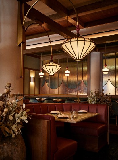 Custom chandeliers arc from columns
