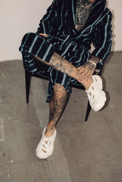 A man sitting in a chair wearing Plastic Soul shoes
