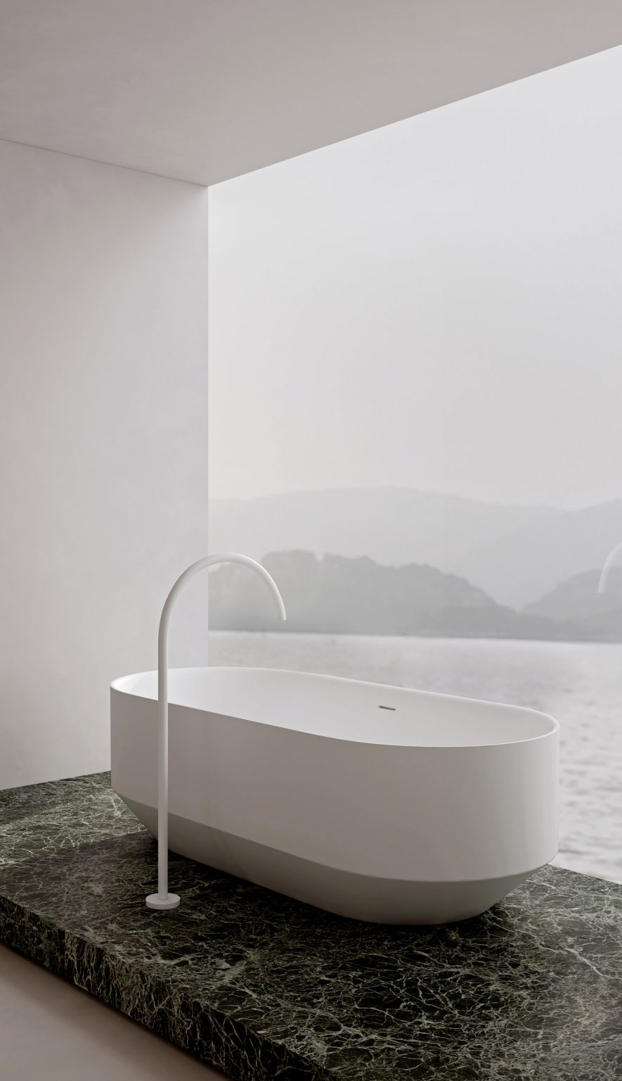 RYO freestanding bathtub on a green marble floor by a floor to ceiling window