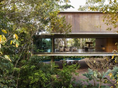 Casa Azul by Studio MK27 with glazed sliding doors on first floor open for a through view of the forest