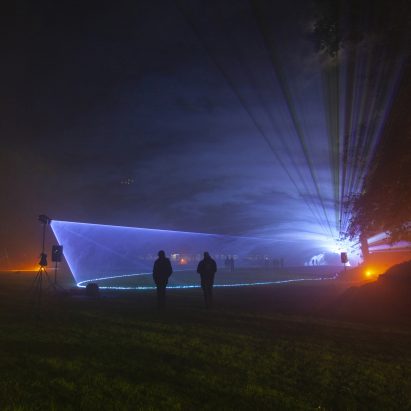 Photograph showing a dark space with light and figures