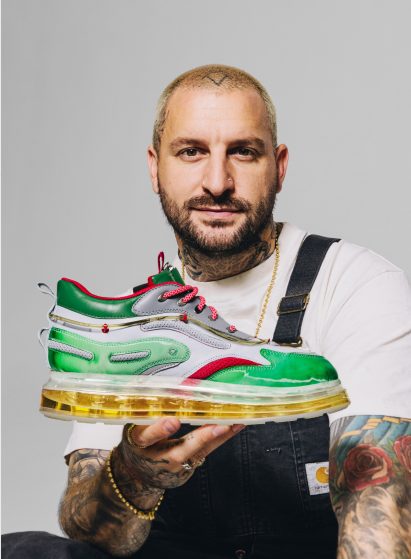 Dominic Cambrione holding up his beer-injected shoes 
