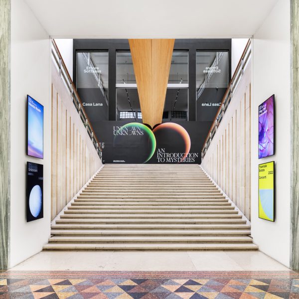 Photo of a stairwell and exhibition poster