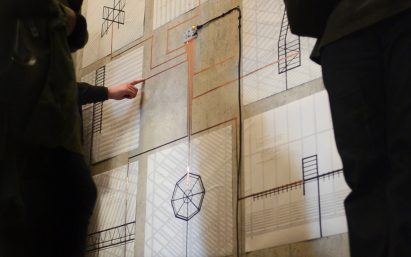 A photograph of people looking at drawings 
