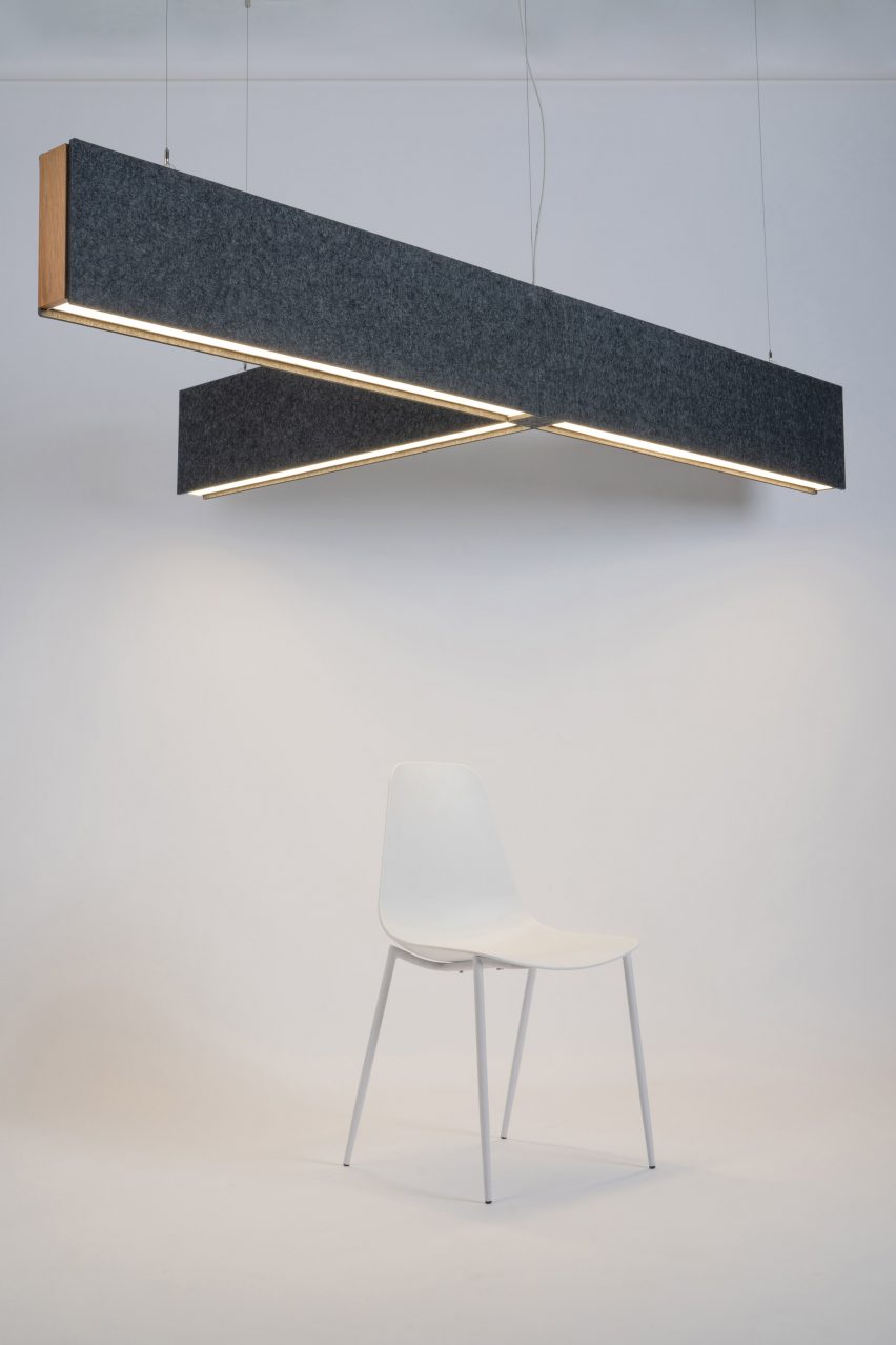 Photograph showing white chair beneath T-shaped lighting fixture on ceiling
