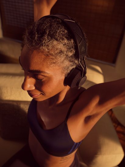 A woman wearing a pair of black Adidas headphones
