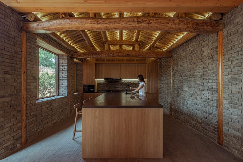 Arch Studio extends courtyard home in China beneath a wave-like wooden roof