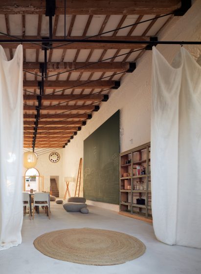 Dining area in the Artchimboldi Menorca retreat framed by white curtains