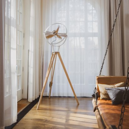 Photograph showing pedestal fan in bedroom setting