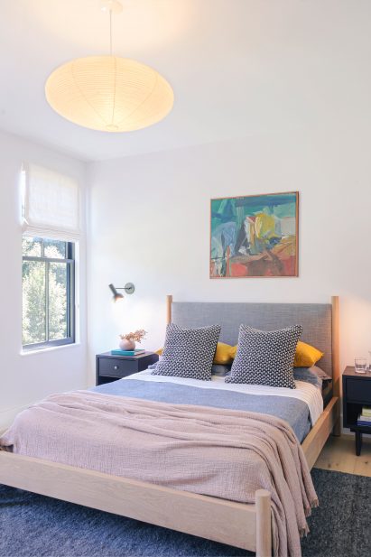 Bedroom in homestead with hanging light and white walls