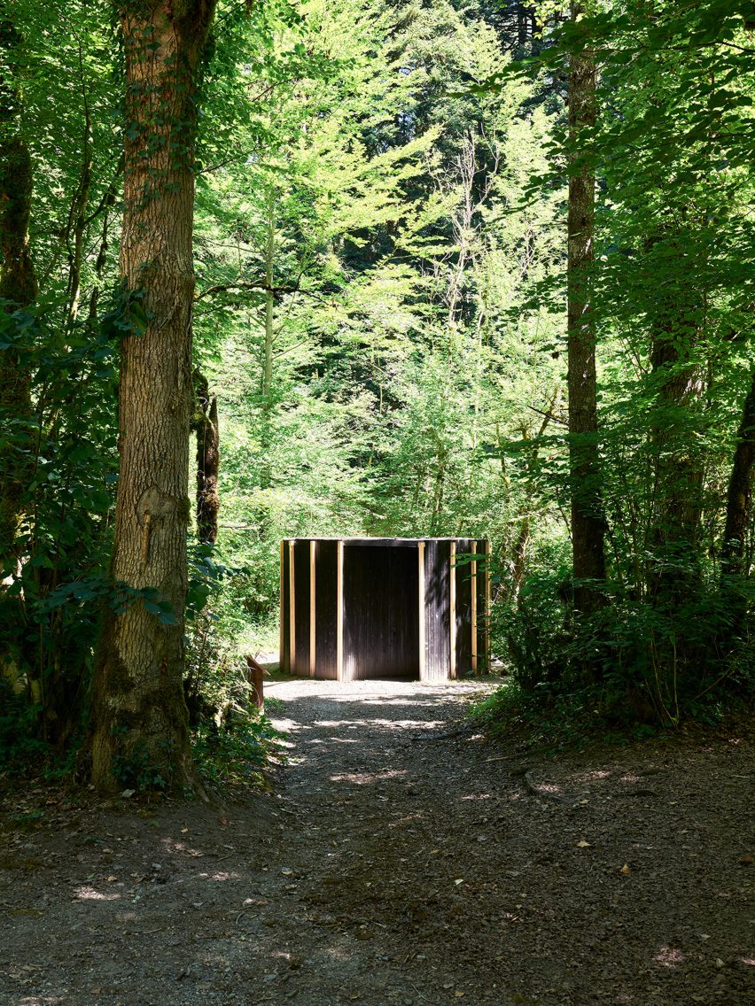A hut in a forest made from dark wood