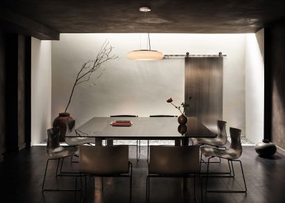 Office basement with textured white walls, black ceiling, and dark floor by Cake Architecture