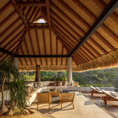 Thatched roof with outside chairs and a deck