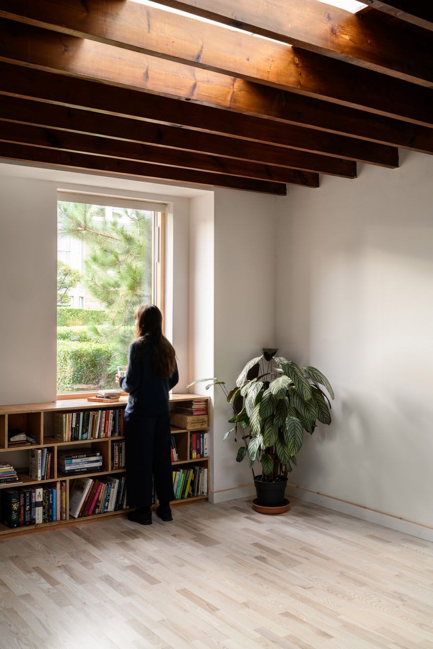Photograph of studio interior showing skylight, window, storage and figure looking out of window