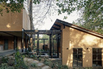 Split-level house in Mexico forest with sloped roof and glass walkway