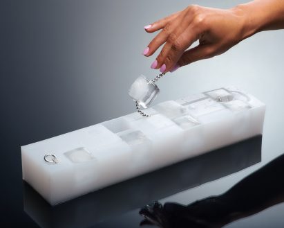 Ice cube necklace on silver chain by Golem being removed from custom silicone ice cube tray