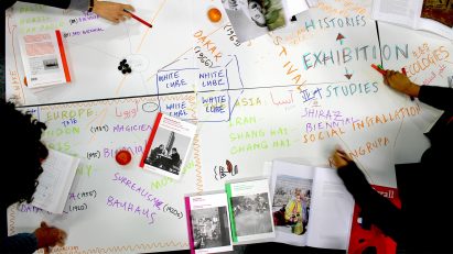 Students gathered around a table to create a mind map