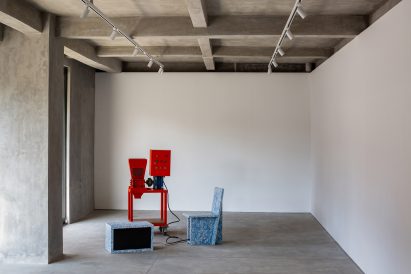 Recycled plastic objects sit in a white gallery