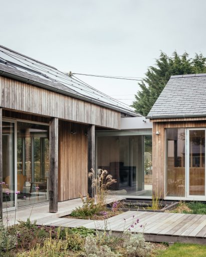 L-shaped house surrounding garden and pond