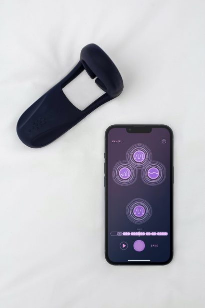Silicone sex toy next to a mobile phone with an app open