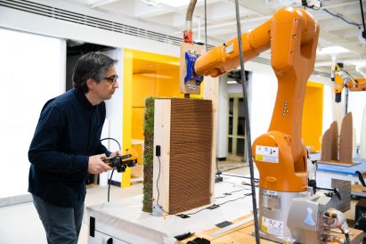 Ehsan Baharlou from the University of Virginia watching a robot 3D-print a small wall from dirt and seeds