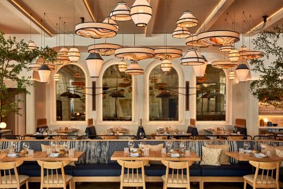 Wide view of restaurant interior facing arched mirrors