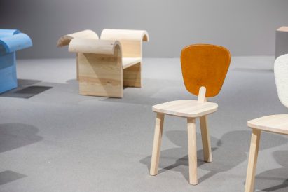 Furniture exhibited, including a chair with an orange back