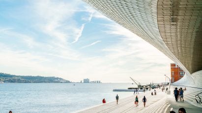A photograph of students sitting by a harbour